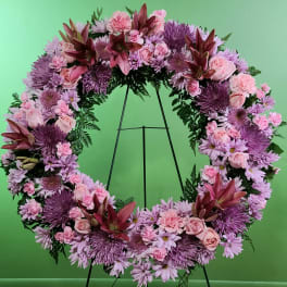 Large pink and purple floral wreath on a stand