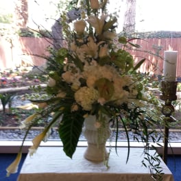 Tall white floral arrangement in a pedestal vase