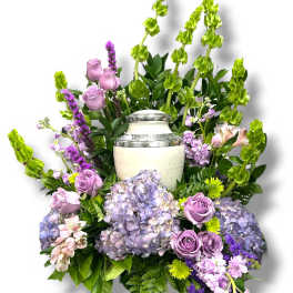Lavender roses and hydrangeas arranged around a white urn