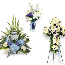 Three white and blue floral funeral arrangements, including a standing spray and urn tribute