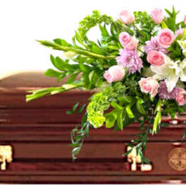 Pink and white floral spray on a casket