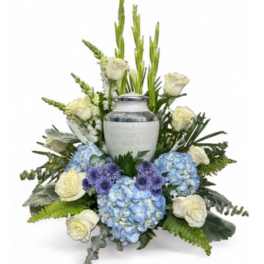 White urn centerpiece with blue hydrangeas and white roses