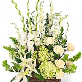 White floral arrangement in a wicker basket with tall green stems