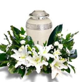 White lilies arranged around a cream urn