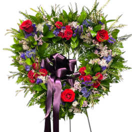 Heart-shaped floral wreath with red roses and a purple ribbon