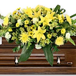 Yellow floral arrangement on a wooden casket