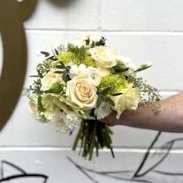 Handheld bouquet of cream roses and green hydrangeas