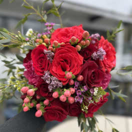 Bouquet of red roses with pink berries and greenery