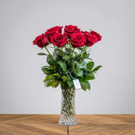 Red roses arranged in a clear glass vase