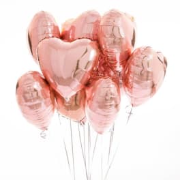 Cluster of rose gold heart-shaped balloons on strings