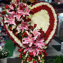 Heart-shaped floral spray with pink lilies and red roses