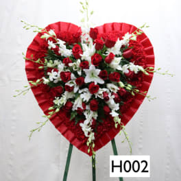 Heart-shaped red floral standing spray with red roses and white lilies