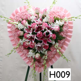 Heart-shaped pink floral standing arrangement with roses and lilies