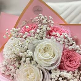 Pink and white roses with baby's breath in pink wrapping