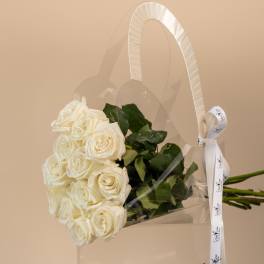 White rose bouquet in a clear gift bag with a ribbon handle