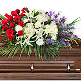 Floral casket spray with red, white, and purple flowers