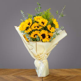 Bouquet of yellow sunflowers wrapped in cream paper