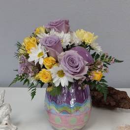Bouquet of lavender roses and white daisies in a painted glass vase