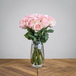 Pink roses arranged in a clear glass vase