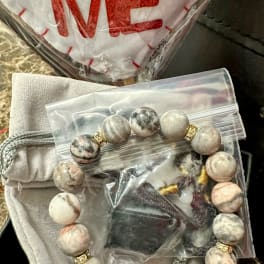 Beaded bracelet and a heart-shaped item in plastic packaging