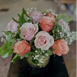 Pink and peach roses arranged in a glass vase