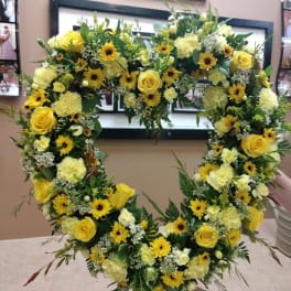 Heart-shaped floral wreath with yellow roses and daisies