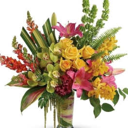 Tropical bouquet in a glass vase with pink lilies and yellow orchids