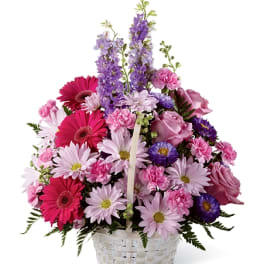 Basket of pink and purple mixed flowers with daisies and roses