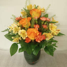 Orange roses and yellow alstroemeria in a dark vase