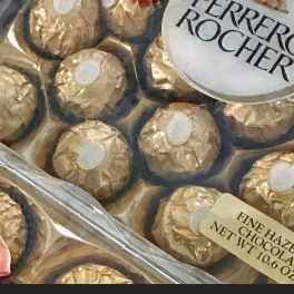 Boxed Ferrero Rocher chocolates with gold wrappers and a pink ribbon