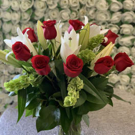 Red roses and white lilies in a clear glass vase