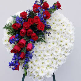Heart-shaped floral spray with red roses, white daisies, and blue flowers