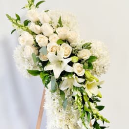 White floral standing spray with roses, lilies, and chrysanthemums on an easel
