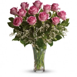 Pink roses arranged in a clear glass vase with white filler flowers