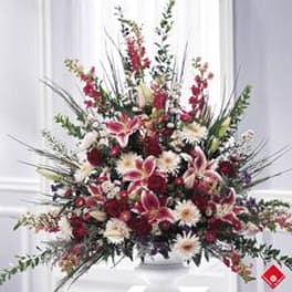 Large red and white floral arrangement in a white vase