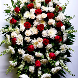 Large standing spray of red and white flowers on an easel