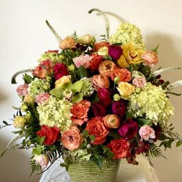 Large mixed bouquet in a green ceramic vase with roses and hydrangeas