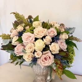 Bouquet of pale pink and cream roses in a textured vase