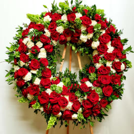 Large wreath of red roses and white carnations on a wooden easel