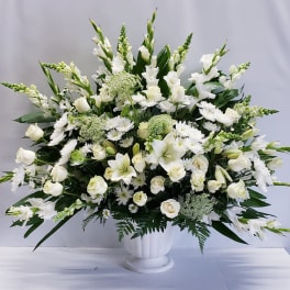 Large white floral arrangement in a white pedestal vase