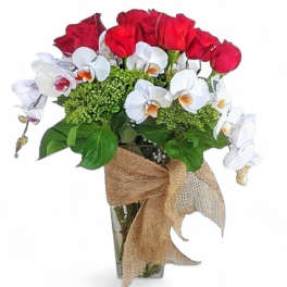 Red roses and white orchids in a glass vase with a burlap bow