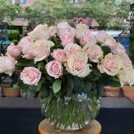 Large bouquet of pale pink roses in a clear glass vase
