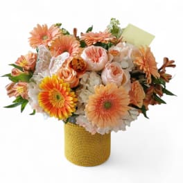 Peach and white mixed bouquet in a yellow wrapped vase