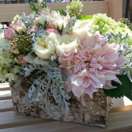 Pastel floral arrangement in a birch bark container