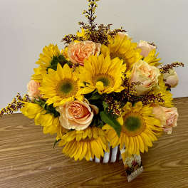 Sunflower and peach rose bouquet in a white vase