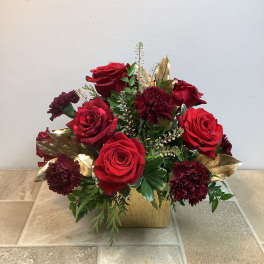 Red roses and burgundy carnations in a gold vase