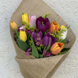 Bouquet of multicolored tulips wrapped in burlap