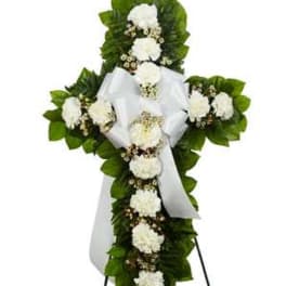 White floral cross wreath with a satin ribbon