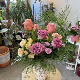Pink and peach roses arranged in a decorative vase