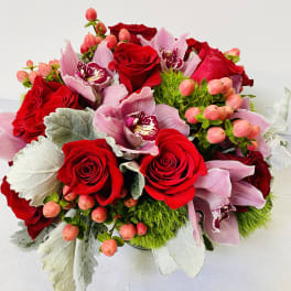 Bouquet of red roses and pink orchids with berry accents